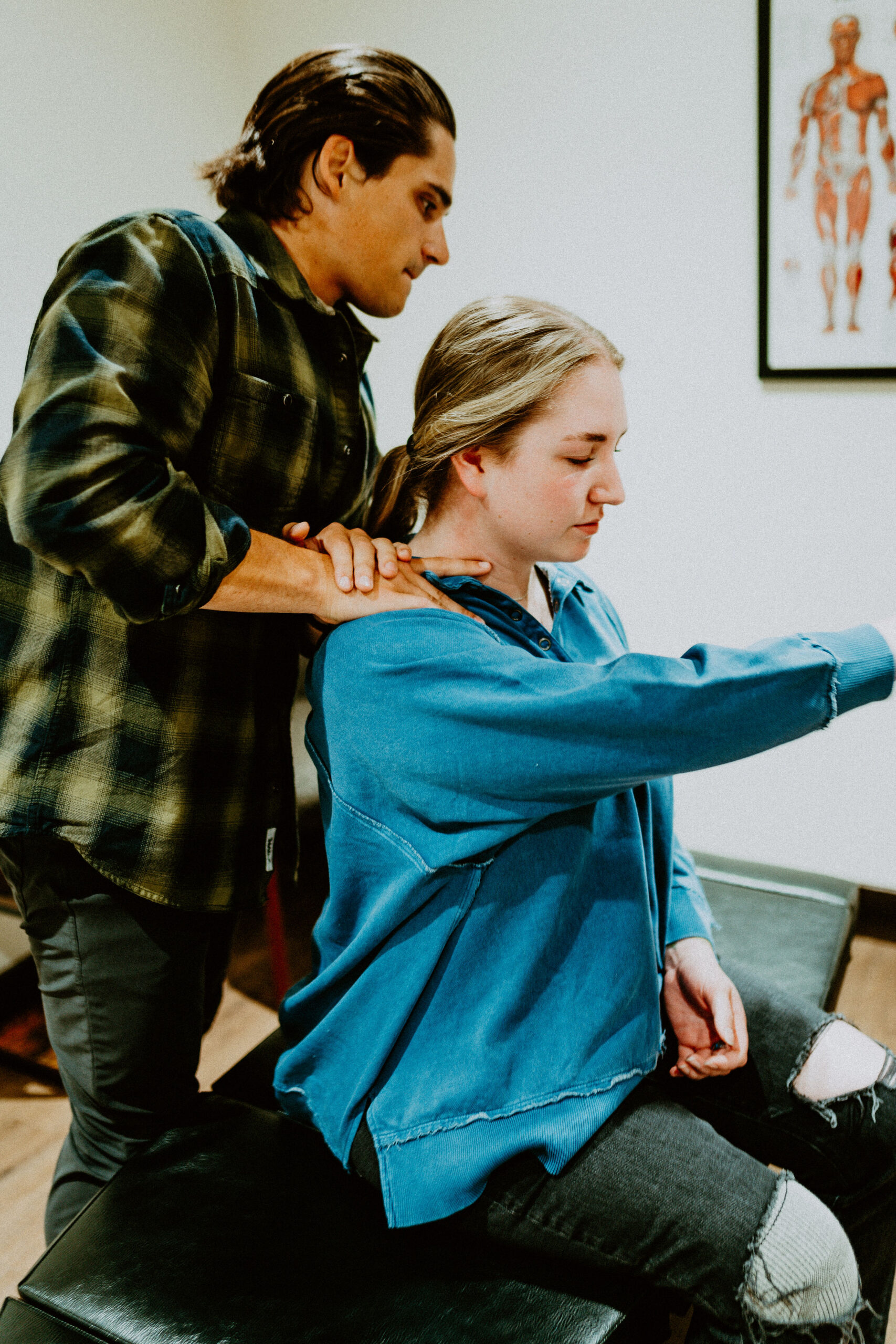 Dr. Kyle DeLamielleure evaluating shoulder movement during a chiropractic visit