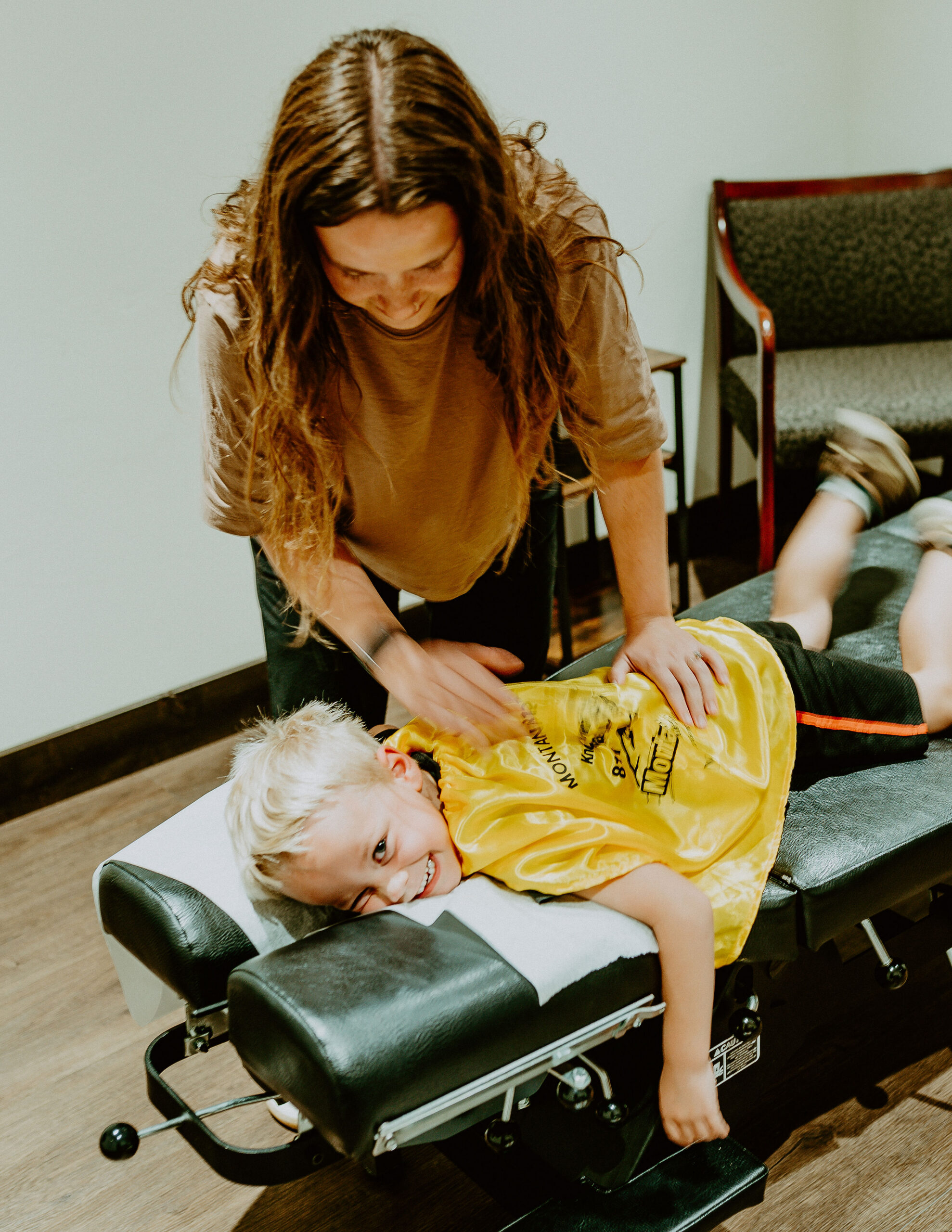 Dr. Claire Schauf performing an age-appropriate pediatric chiropractic assessment